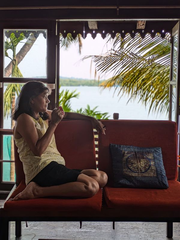 A woman sips tea by a window